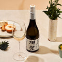 Dassai “39” Junmai Daiginjo with a wine glass, served with cheese and fruits